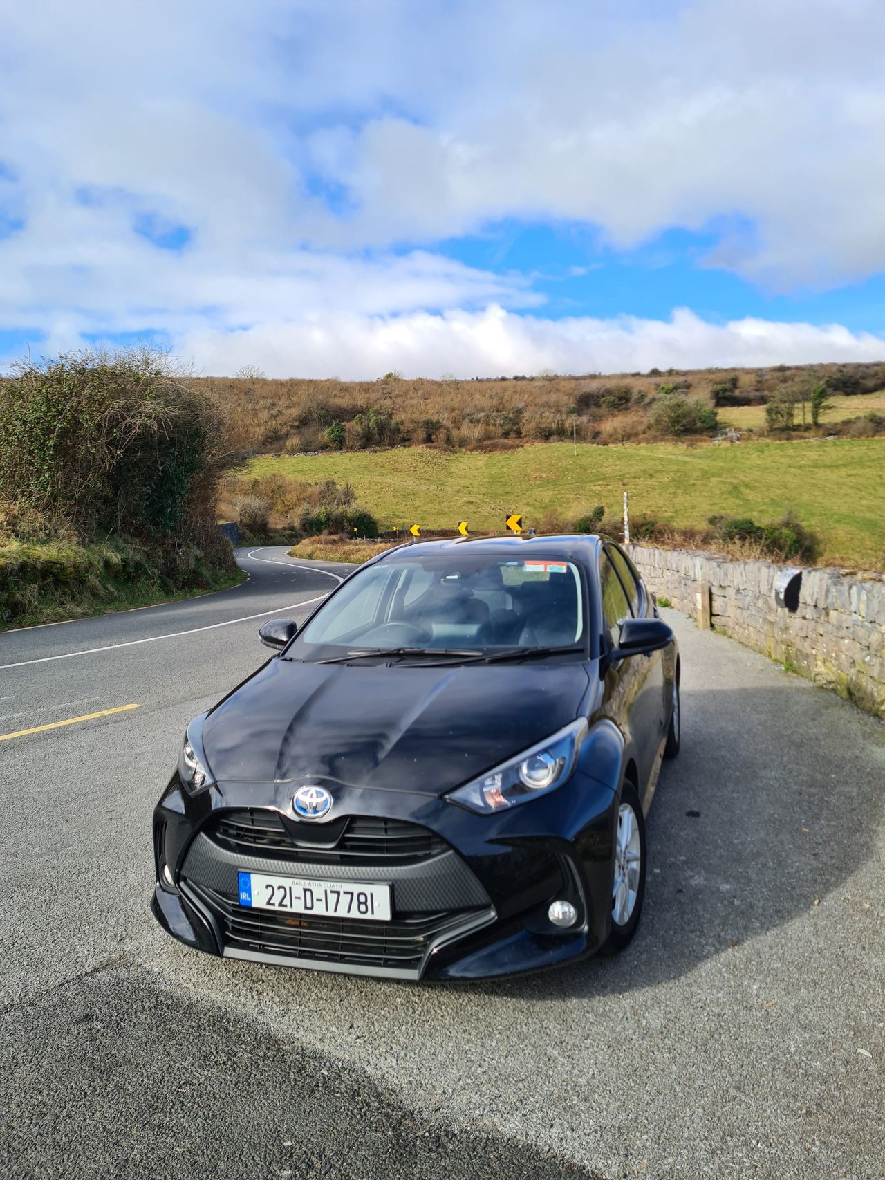 Black car with steering wheel on the right on a winding mountain road