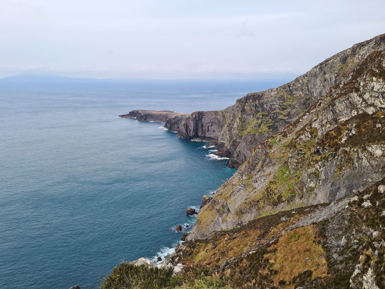 Sea cliffs stretching along the water with no vegetation in them