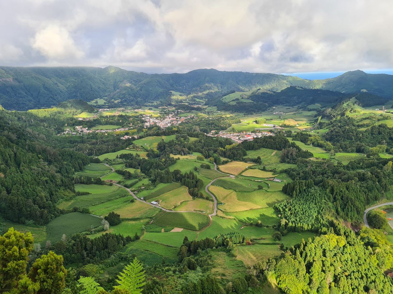 Lush, green view of a valley, with villages from above in the Azores