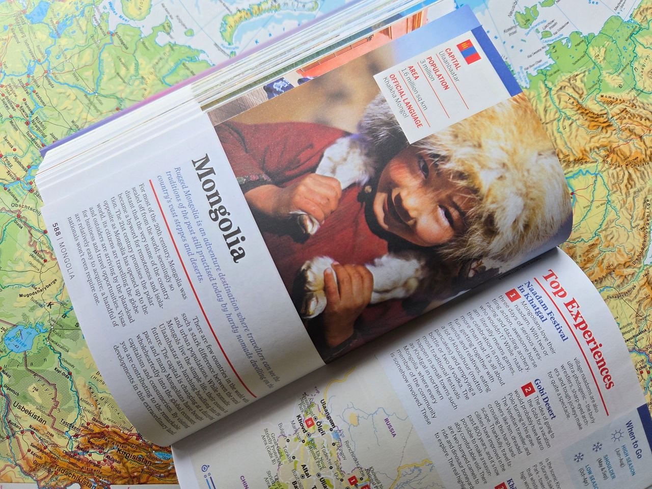 Travel book, opened at Mongolia, on a map.