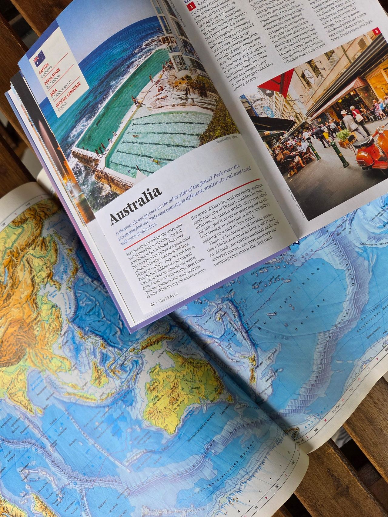 Travel book opened at Australia on a map.