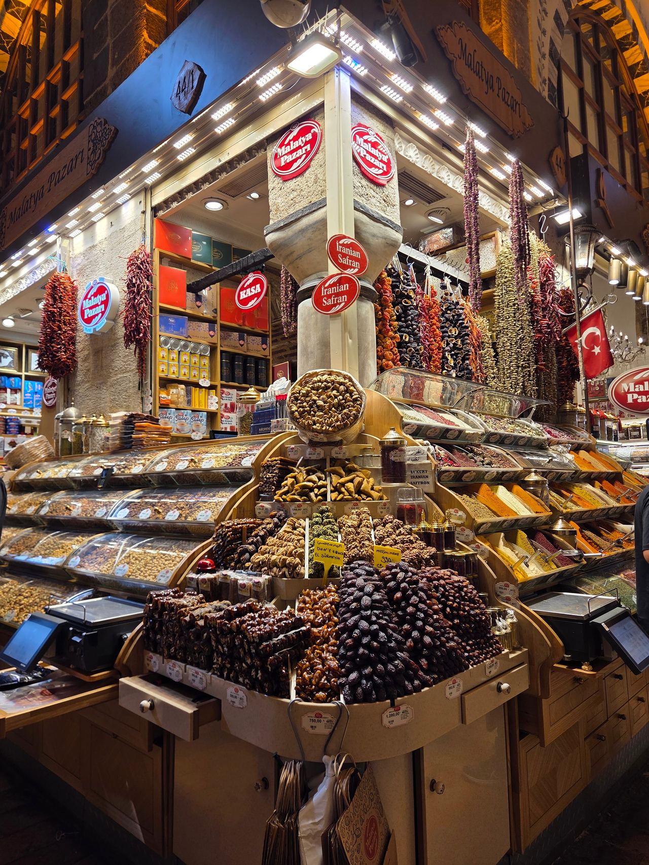 A brightly lit Turkish spice shop displays pyramids of dried fruit, nuts, spices, and sweets
