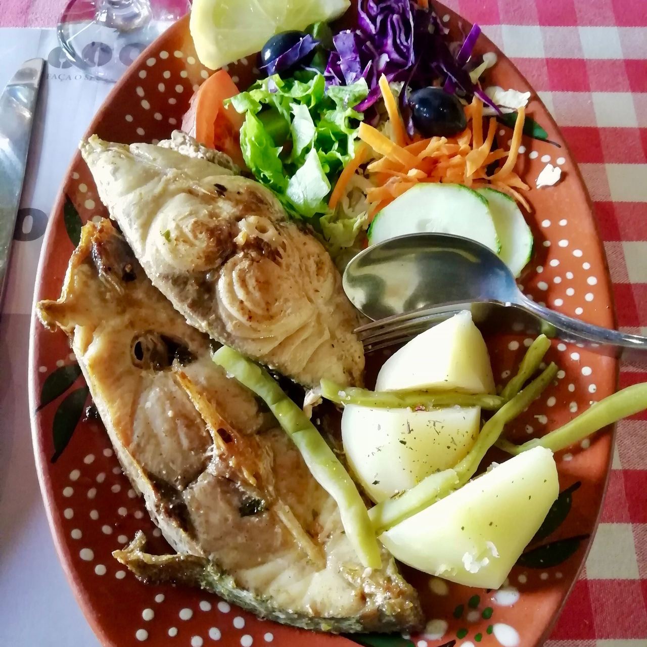 Azorean dish of grilled fish filet and boiled vegetables on a terracotta plate